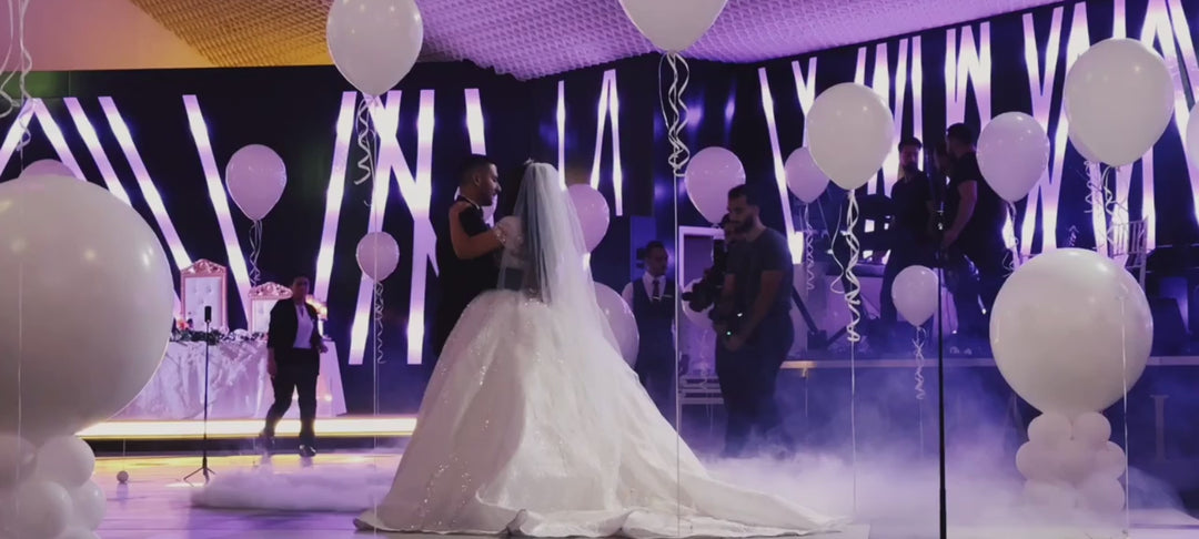 Hochzeitstanz mit Piñata-Ballons, weiße Ballons fliegen durch den Saal